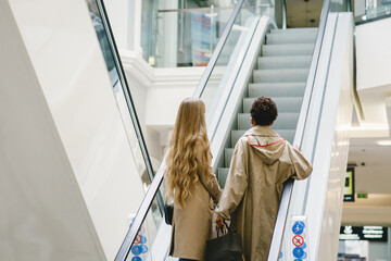 Happy mixed girls walking the store with shopping bags