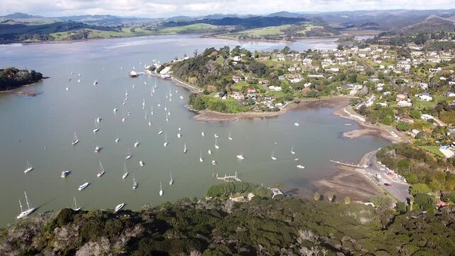 A lowering aerial drone shot of Mangonui town, harbour and boats on the Doubtless Bay in Northland, New Zealand, Aotearoa