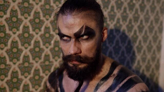 brutal and wild face art on man, war paint for muscular male demon