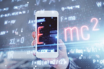Double exposure of man's hands holding and using a phone and formulas drawing. Education concept.