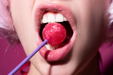 Sexuelle Lippen mit Süßigkeiten, sexy süße Träume. Weiblicher Mund leckt Chupa Chups, lutscht Lutscher. © Volodymyr