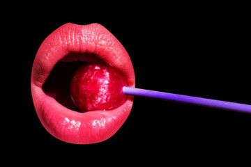 Lollipop in woman mouth, red lipstick. Woman licking a red shiny lollipop. Close up. Sexy woman...