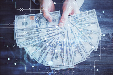 Multi exposure of technology drawing hologram and us dollars bills and man hands. Data concept