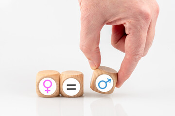 Eine Hand legt Symbole männlich, weiblich und ein Gleichheitszeichen. Konzept Gleichberechtigung...