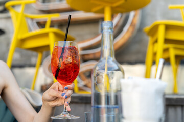 Woman drinking aperol cocktail in the restaurant