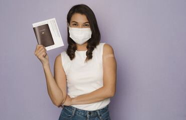 Woman wearing protective hygiene face mask holding passport and vaccination record card show to camera. Concept for new normal  traveller certificated document after coronavirus or Covid-19 pendemic - 444670573