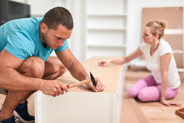 Obraz premium Husband and wife assembling new furniture - renovation home concept.