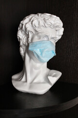 Bust of Julius Caesar in a protective mask against the virus