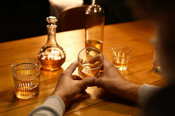 Senior man with glass of drink late in evening at home, closeup