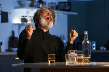 Angry senior man in kitchen at night