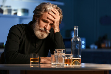 Drunk senior man in kitchen at night