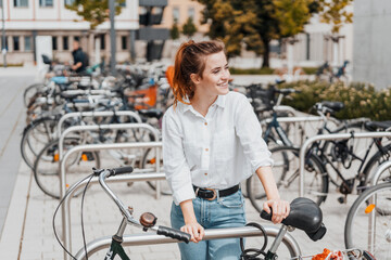 Young woman standing at an urban bicycle rank