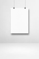 White poster hanging on a clean wall with clips