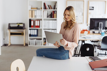 Professional young woman using a handheld laptop in the office