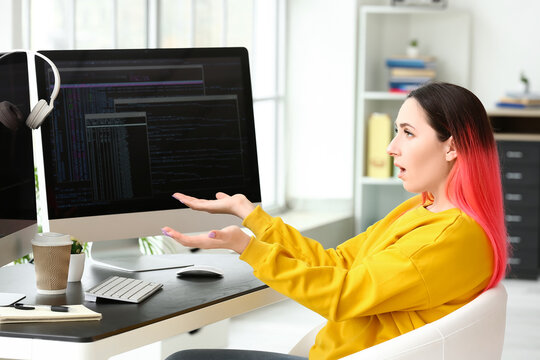 Shocked female programmer working with computer in office