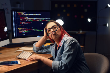 Fototapeta na wymiar Female programmer working in office at night