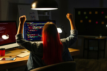 Female programmer working in office at night