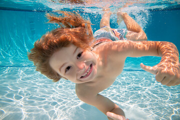 Happy kid boy swim and dive underwater, kid with fun in pool under water. Active healthy lifestyle,...