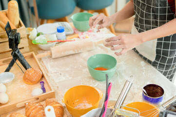 A Beautiful asian woman is making bakery ,   live streaming or recording video on social media in her house