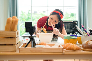 A Beautiful asian woman is making bakery ,   live streaming or recording video on social media in her house