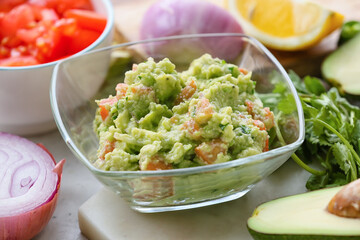 Bowl with tasty guacamole on table, closeup