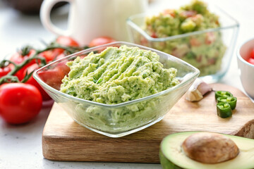 Bowl with tasty guacamole on table, closeup