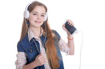 Happy little girl in jeans jacket listening music with smartphone