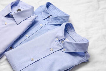 Stylish male shirts on fabric background, closeup