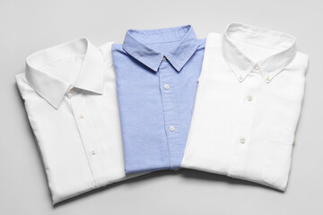 Stylish male shirts on light background