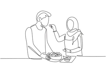 Single continuous line drawing beautiful Arab wife feeds her husband food and in front of him is bowl filled with salad. Cooking together in kitchen. One line draw graphic design vector illustration