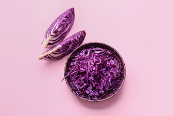 Bowl with fresh purple cabbage on color background
