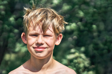 Smiling boy posing for camera in green park