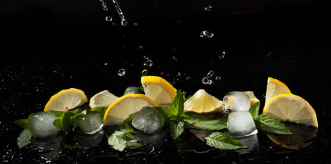 Mint, lemon and ice in splashes of water on a dark background