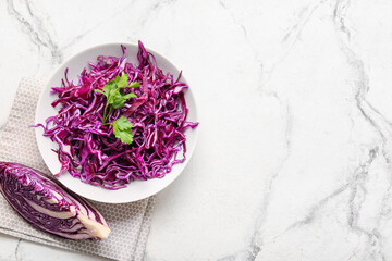 Obraz na płótnie Canvas Bowl with cut fresh purple cabbage and parsley on light background