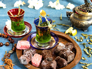 orientalische Teegläser mit grünen Tee mit zitrone, keksen und  komboloi auf schönen tablett