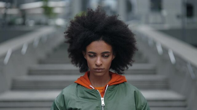 Close-up portrait of nice-looking multi-race beautiful elegant young woman with curly hair looking into camera with clam emotions. Fashion, beauty and female portraits concept.