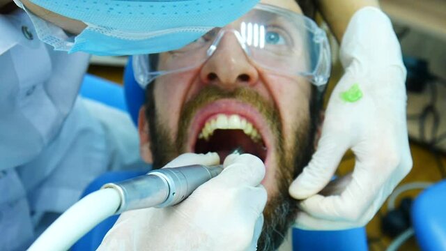 Close-up of dentists hands with latex gloves giving a fluoridation procedure to a man