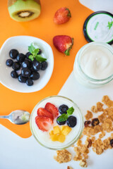 Healthy breakfast with granola, yogurt and fresh berries and kiwi, view from above