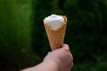 Delicious classic ice cream in a woman's hands. Natural homemade closeup. Sweet dessert for summer. Refreshes in hot weather. Healthy eating, organic food. Take away the traditional product