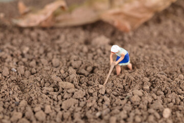 Fototapeta na wymiar Miniature model of farmers working on the soil