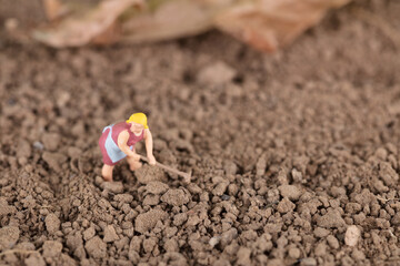 Miniature model of farmers working on the soil