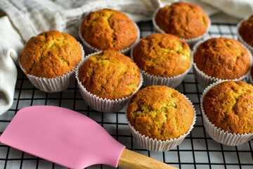 home baking with banana bread muffins on a cooling rack with pink spatula 