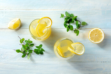 Lemonade. Homemade fresh drink with lemon and mint, with ice, overhead flat lay shot on a wooden...
