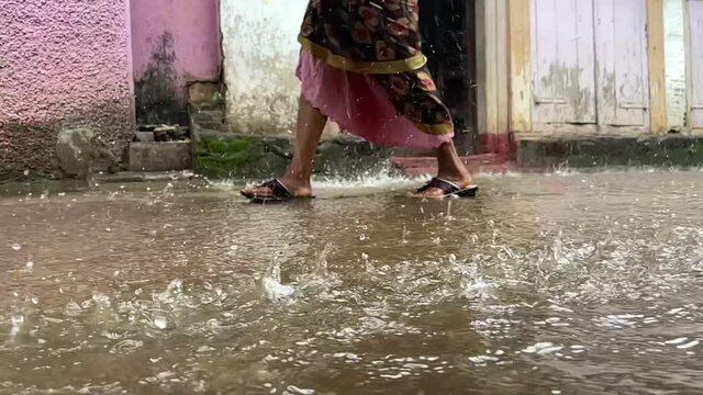 Indian Woman Walking On Deep Puddles During Rainy Season At Trimbakeshwar City In Trimbak, Maharashtra, India. - Slow Motion