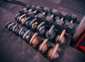 Dumbbells and kettlebells on a gym's floor. A workout template perspective view, photo shot