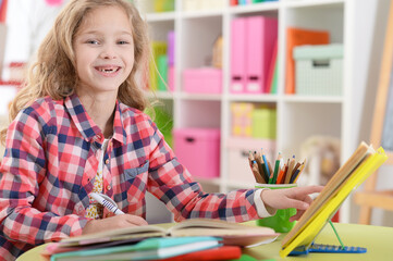 Cute teen girl doing homework in her room