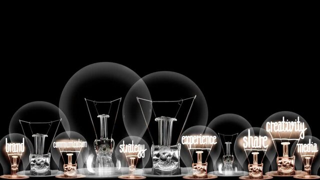Group of light bulbs in a row going from dark to light with Story Telling, Marketing, Content, Creativity and Share fiber text on black background. High quality 4k video.