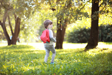 Children with briefcases for a walk in the park. School break. The beginning of the children's studies.