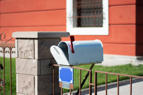 Just in front of the garden gate is an old-style mailbox with an open lid. Selective Focus Mail Box