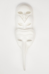 White venetian masks of different shapes and types on a background. High key